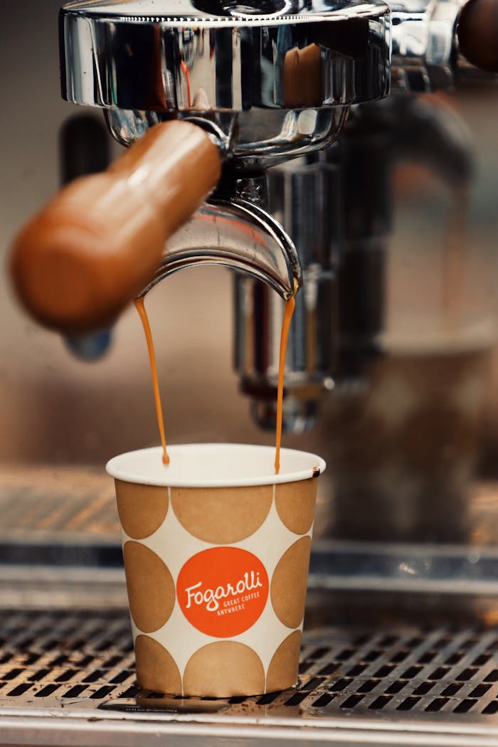 Close-up of espresso machine brewing coffee into a paper cup in Jönköping, Sweden.